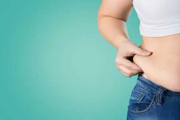 Image of woman pinching her love handles to show weight gain Winkfield